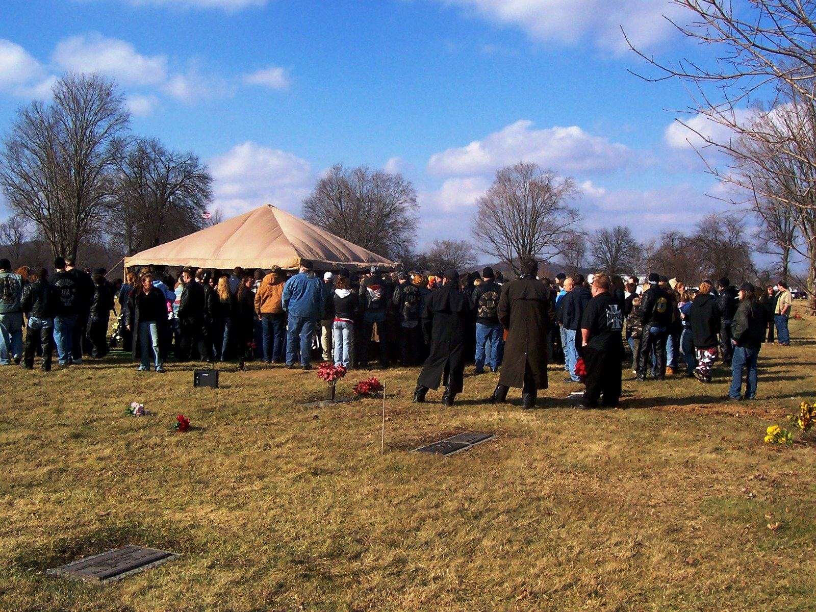 Bikers gathered at a graveside service under a canopy, February 2013