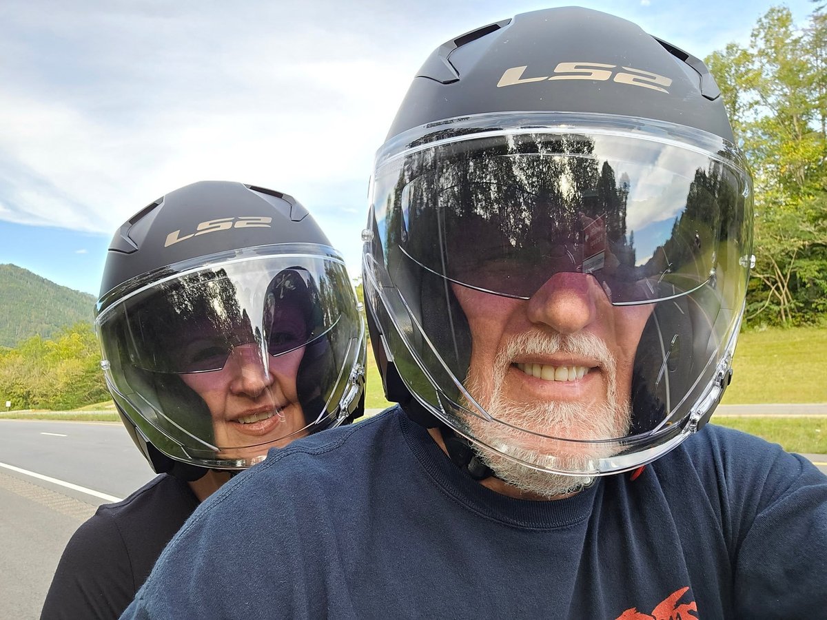 Tom and Cathy Hughes on a motorcycle together on a mountain road