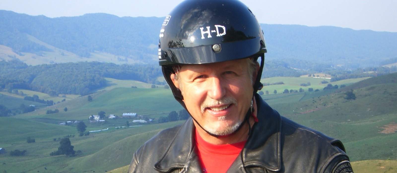Pastor Tom Hughes in his leather jacket and helmet above the Blue Ridge