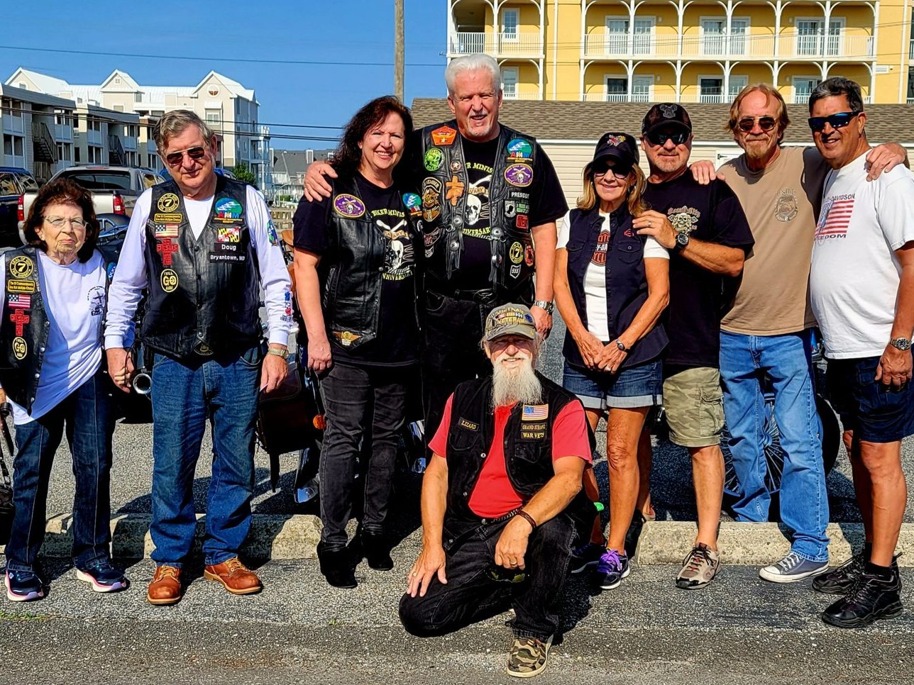 Adventist Motorcycle Ministry riders lined up for a group photo in a beach-town parking lot