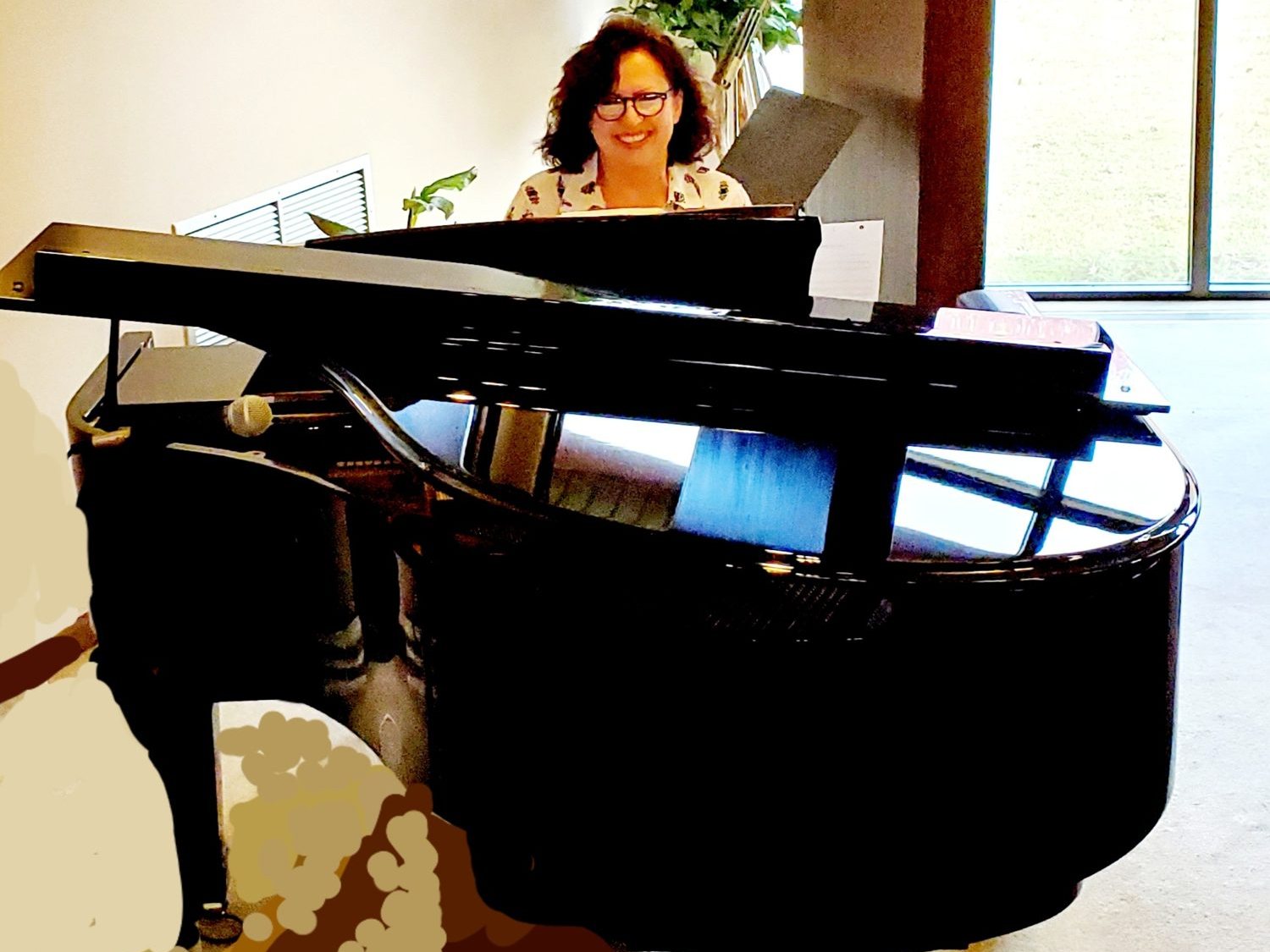 Cathy Hughes at a grand piano in a church
