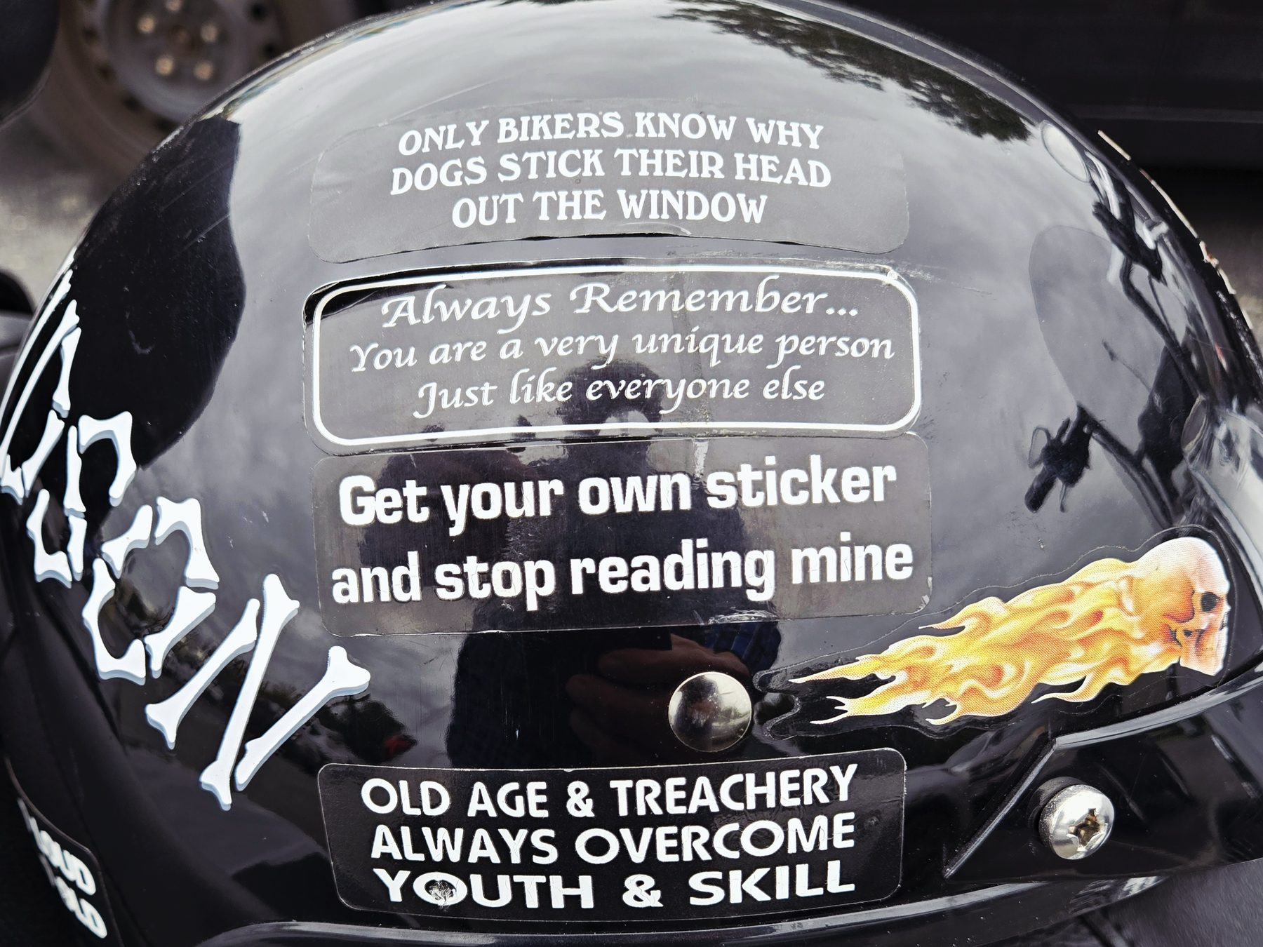 Close-up of the bumper stickers on Tom Hughes's helmet, including 'Get your own sticker and stop reading mine'