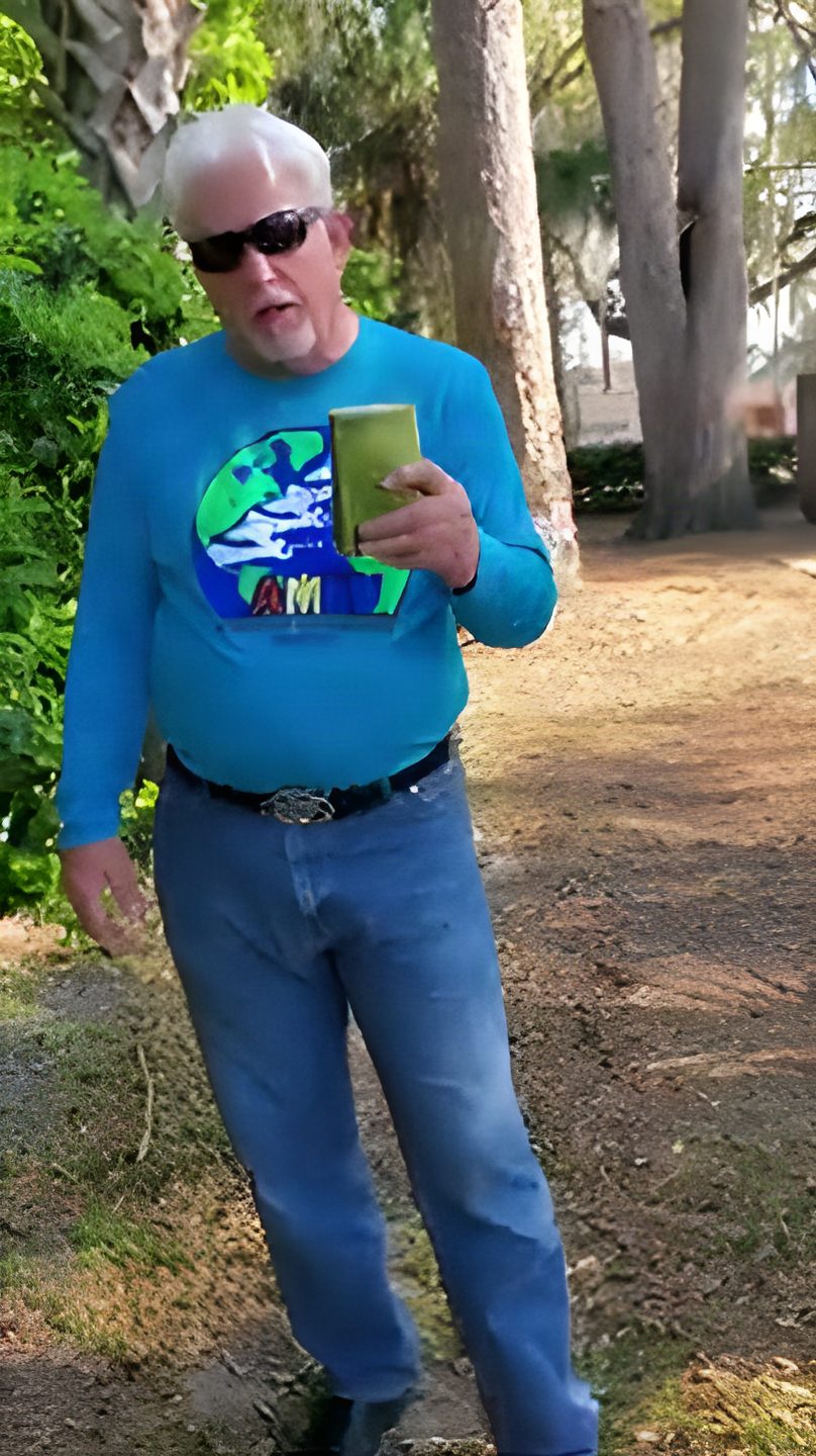 Tom Hughes, mid-testimony, holding his Bible outdoors